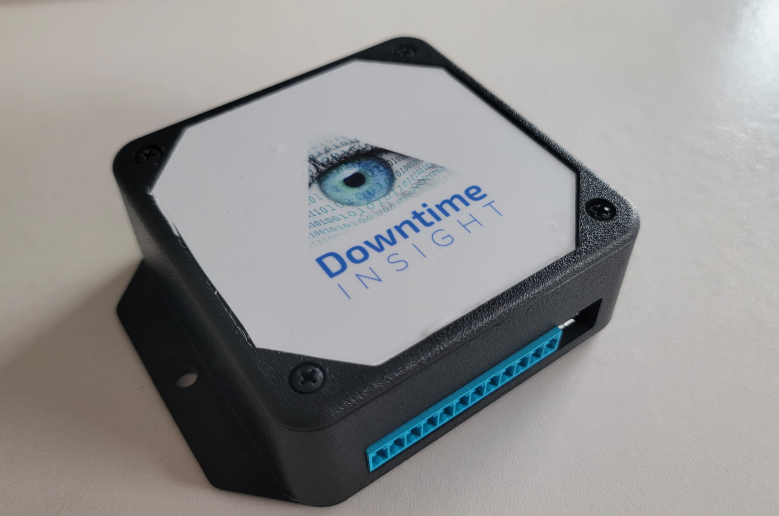 The Downtime Insight device: a black enclosure with the branded eye logo on its top face and a blue plug-in connector along one side for power and the sensor input.